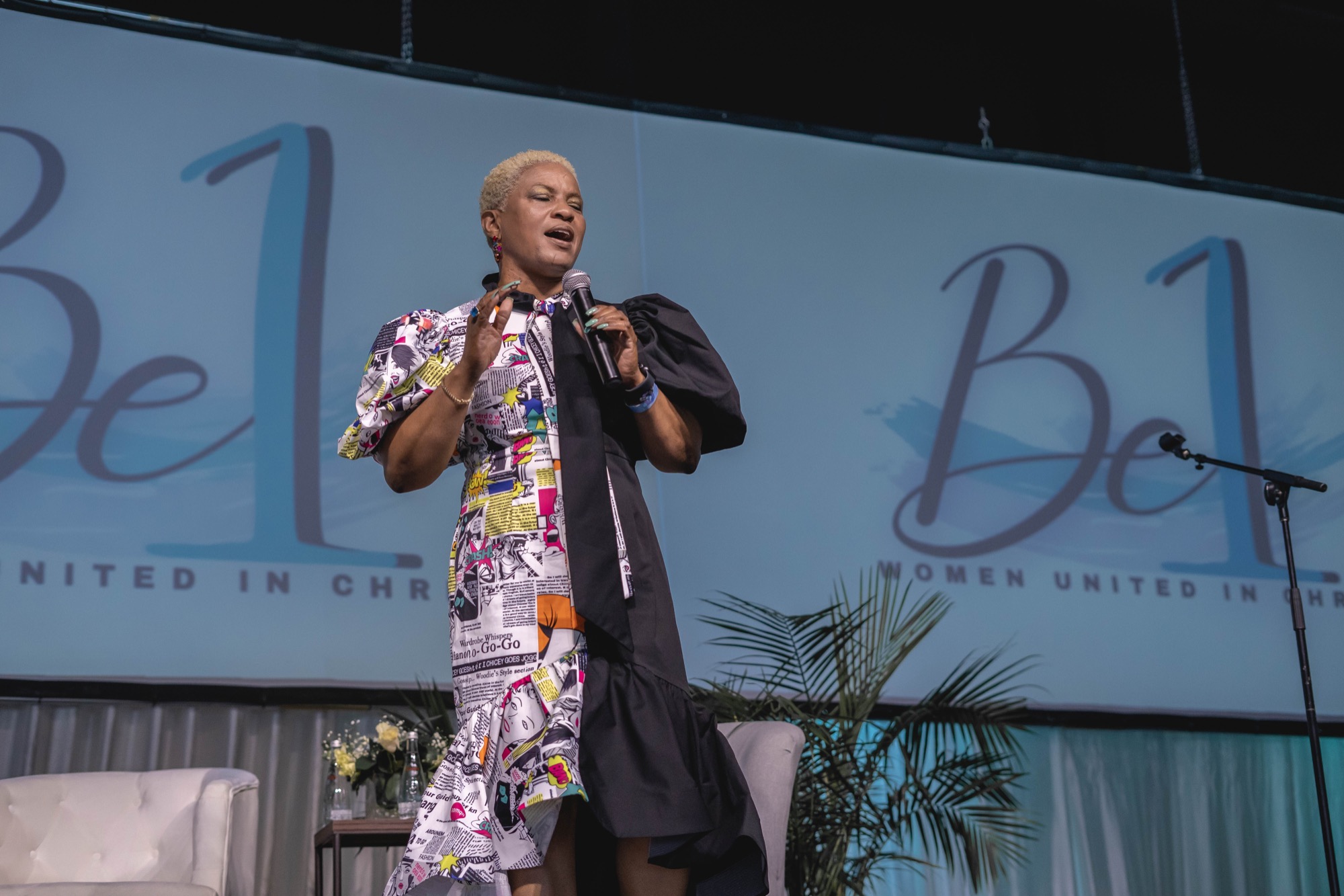 Lesa Willis singing on stage at a past Be1 Experience